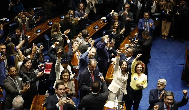 Morada FM — O Senado aprovou, na quarta-feira (14), uma Proposta de Emenda à Constituição (PEC) que prevê o fim da escala de trabalho 6×1 e estabelece dois dias de folga remunerada por semana, sem redução salarial. A proposta também prevê diminuir a jornada semanal de 44 para 40 horas. Segundo as informações divulgadas, a PEC recebeu 75 votos favoráveis e um contrário nos dois turnos de votação. O senador Hamilton Mourão (Republicanos-RS) foi o único a votar contra o texto. A proposta altera a Constituição Federal para garantir dois dias de descanso semanal remunerado aos trabalhadores. Um dos dias deverá ser preferencialmente o [&hellip;]